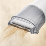 Close-up of the deshedding comb catching loose pet fur